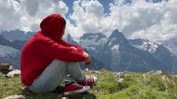 Νεαρός Όμορφος Άντρας Κόκκινη Κουκούλα Απολαμβάνει Θέα Στα Βουνά — Αρχείο Βίντεο
