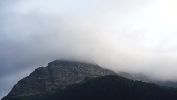曇天に対する山のピーク 自然の中で晴れた日に明るい曇りの空に対して位置する壮大な岩のピーク — ストック動画