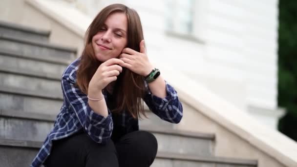 Mujer Sonriente Adulta Tocándose Pelo Sentada Los Escalones Del Palacio — Vídeos de Stock