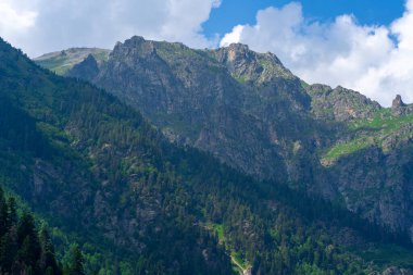 Güneşli bir günde parlak bulutlu gökyüzüne uzanan muhteşem kayaların zirveleri..