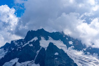 Kayalık dağlar güneşli bir günde bulutlarla örtülüydü. Çarpıcı dağ manzarası