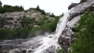 Dağlık bölgede akan su yolunu kapatın. Dağ nehri yazın ağaçlık alanda taşların arasından akar.