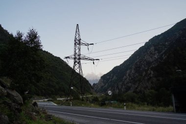 Dağlık bölgede yüksek voltajlı elektrik iletim kulesi. Akşamları dağlarda elektrik hattı nesnesi
