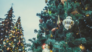 Akşam sokağındaki Noel ağacı. Düşük açılı kozalaklı ağaç ve geleneksel Noel süslemeleri akşam kentte sokakta bulunuyor..