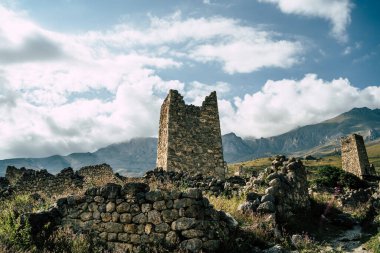 Yeşil dağlık arazideki eski taş kule. Yeşil tepenin üzerinde bulunan antik taş bina yaz günü orman ve sisle kaplı dağlara karşı..