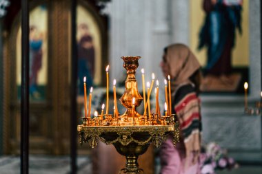 İçi yanan mumlarla dolu Hristiyan kilisesi. Geleneksel Hıristiyan kilisesinin içindeki altın süslemeli şamdanlara yerleştirilmiş yanan mumlar..