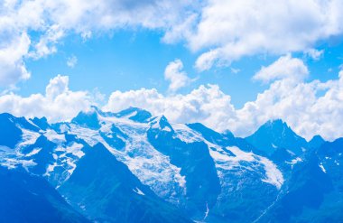 Güneşli bir günde kayalık dağlar bulutlarla örtülüydü..