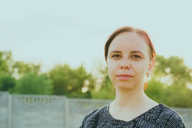 Kırsal kesimde kameraya bakan bir kadın var..