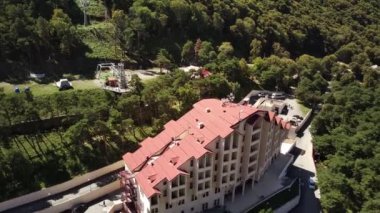 Ingushetia, Rusya 2 Eylül 2020 Highland bölgesindeki otel binası. Güneşli bir günde tepedeki modern otelin ön cephesinin insansız hava aracı görüntüsü