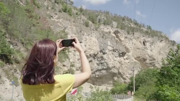 年轻女子用智能手机拍摄山景 用手机拍摄高山的女游客 — 图库视频影像
