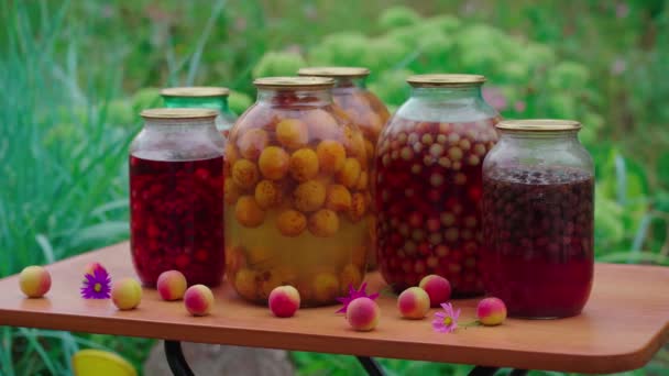 汤锅放在桌上的罐子 园中的花朵和水果旁边放着密封的玻璃瓶 上面放着汤锅 — 图库视频影像
