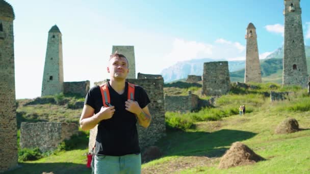 旅行者は山の古代遺跡の近くに立っている 若い男性観光客のサイドビューバックパック立って — ストック動画