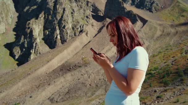 Молодая Женщина Просматривает Мобильный Телефон Стоит Холмистой Местности Самка Путешественница — стоковое видео