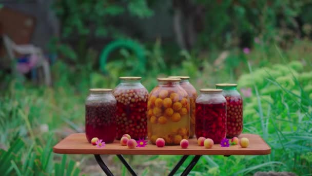 街上有很多玻璃瓶的罐装水果 花园里的腌制水果罐子在桌子上 — 图库视频影像