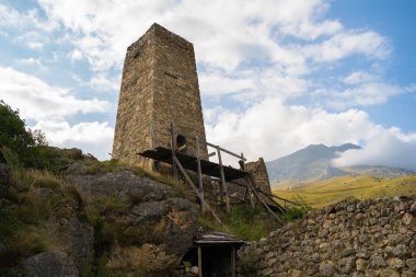 Yeşil dağlık arazideki eski taş kule. Yeşil tepenin üzerinde bulunan antik taş bina yaz günü orman ve sisle kaplı dağlara karşı..