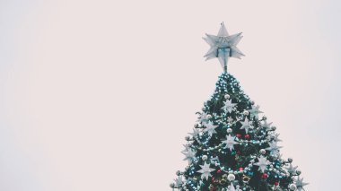 Akşam sokağındaki Noel ağacı. Düşük açılı kozalaklı ağaç ve geleneksel Noel süslemeleri akşam kentte sokakta bulunuyor..