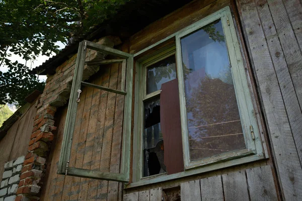 古い建物の壊れたガラス窓 古い放棄された木造建築物の部分的に壊れたガラスと木製の窓枠 — ストック写真