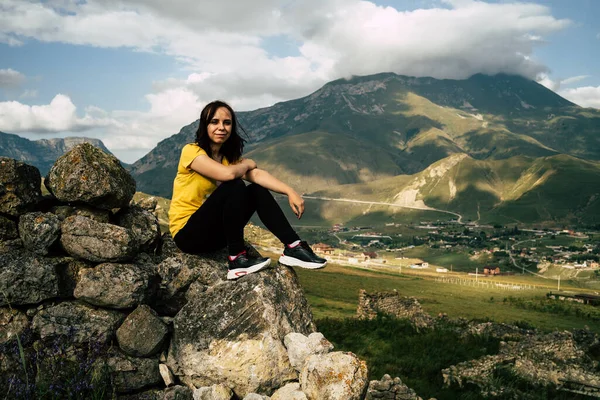 Yorgun bir seyyah tepede dinleniyor. Dağlarda aktif bir yürüyüşten sonra taşın üzerinde oturan bitkin erkek turist.