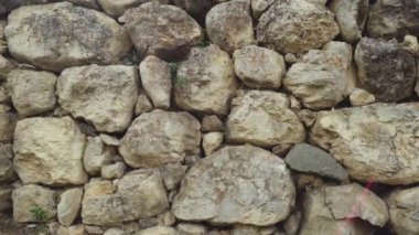 Dikişleri olan eski taşların dokusu. Sefil duvarcılığa yakın çekim. Değişik antik kaldırım taşlarından yapılmış taş duvar.