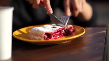 Bir kadın kirazlı turtayı bıçakla kesiyor. Kirazlı ev yapımı meyveli bisküvi..