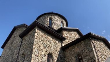 Yeşil dağlık arazide eski taş kuleler. Eski şehrin antik taş binaları dağlara karşı yeşil tepenin üzerinde yer alır.