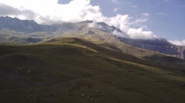 Dağ zirveleri bulutlu gökyüzüne karşı. Güneşli bir günde parlak bulutlu gökyüzüne uzanan muhteşem kayaların zirveleri.