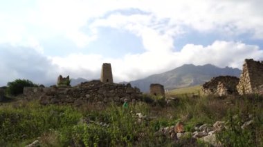 Yeşil dağlık arazide eski taş kuleler. Eski şehrin antik taş binaları dağlara karşı yeşil tepenin üzerinde yer alır.