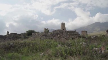 Yeşil dağlık arazide eski taş kuleler. Eski şehrin antik taş binaları dağlara karşı yeşil tepenin üzerinde yer alır.