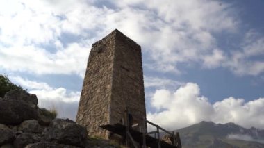 Yeşil dağlık arazide eski taş kuleler. Eski şehrin antik taş binaları dağlara karşı yeşil tepenin üzerinde yer alır.