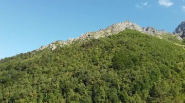 Dağ zirveleri bulutlu gökyüzüne karşı. Güneşli bir günde parlak bulutlu gökyüzüne uzanan muhteşem kayaların zirveleri.