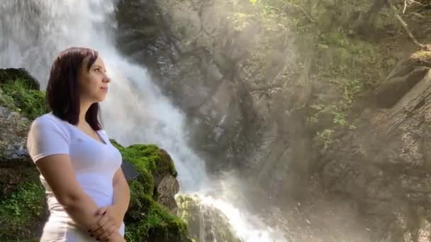 年轻女子站在瀑布前 — 图库视频影像