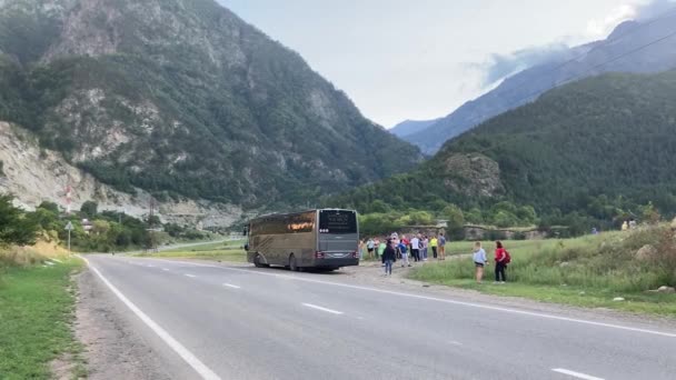 Северная Осетия, Россия 1 сентября 2020 года: Большой туристический автобус стоит на открытом воздухе на горной дороге — стоковое видео