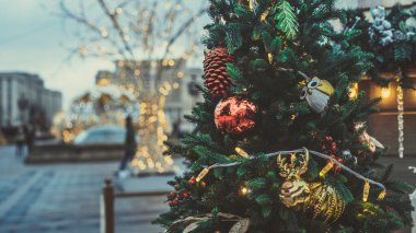 Akşam kentinde Noel ağacının bir kısmını farklı Noel oyuncakları ve çelenklerle kapatın. Şenlik havası yaratmak için dekoratif süslemeleri olan kozalaklı ağaç.