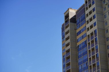 Mavi gökyüzü olan güneşli bir günde modern apartman binaları. Modern bir apartmanın ön cephesi. Modern apartman binası mimarisi