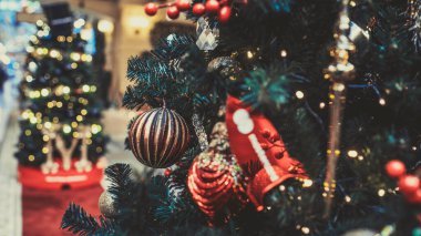 Noel ağacının bir kısmını alışveriş merkezinde farklı Noel oyuncakları ve çelenklerle kapatın. Noel kutlamaları sırasında şenlik havası yaratmak için dekoratif süslerle süslenmiş kozalaklı ağaçlar..