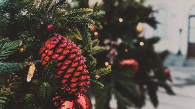 Akşam kentinde Noel ağacının bir kısmını farklı Noel oyuncakları ve çelenklerle kapatın. Şenlik havası yaratmak için dekoratif süslemeleri olan kozalaklı ağaç.