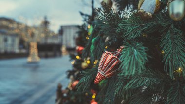 Akşam kentinde Noel ağacının bir kısmını farklı Noel oyuncakları ve çelenklerle kapatın. Şenlik havası yaratmak için dekoratif süslemeleri olan kozalaklı ağaç.