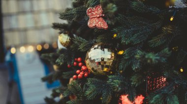 Akşam kentinde Noel ağacının bir kısmını farklı Noel oyuncakları ve çelenklerle kapatın. Şenlik havası yaratmak için dekoratif süslemeleri olan kozalaklı ağaç.