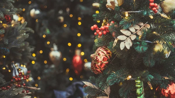 Akşam kentinde Noel ağacının bir kısmını farklı Noel oyuncakları ve çelenklerle kapatın. Şenlik havası yaratmak için dekoratif süslemeleri olan kozalaklı ağaç.