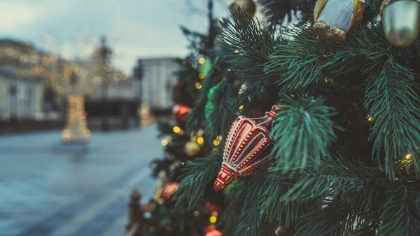 Akşam kentinde Noel ağacının bir kısmını farklı Noel oyuncakları ve çelenklerle kapatın. Şenlik havası yaratmak için dekoratif süslemeleri olan kozalaklı ağaç.