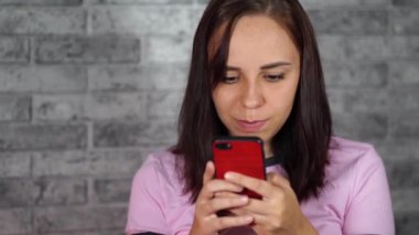 Cep telefonunu kullanan genç bir kadın..