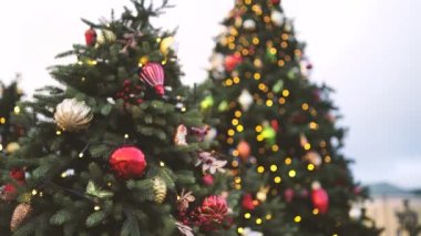 Akşam kentinde Noel ağacının bir kısmını farklı Noel oyuncakları ve çelenklerle kapatın. Şenlik havası yaratmak için dekoratif süslemeleri olan kozalaklı ağaç.