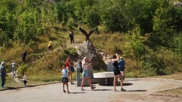Ossétia do Norte, Rússia 1 de setembro de 2020: Pessoas caminhando no lugar turístico no dia ensolarado. Turistas considerando pontos turísticos em excursão em terreno montanhoso. — Vídeo de Stock