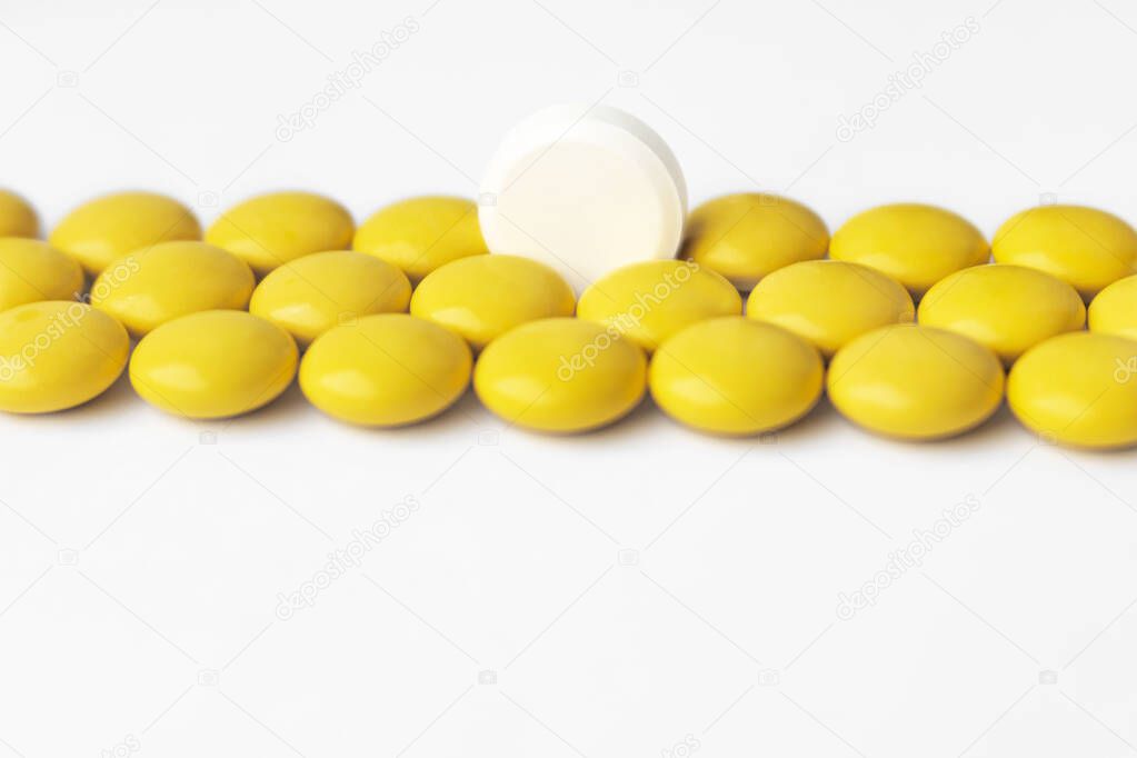 The tablets are yellow and one white tablet in the center. Direct view.