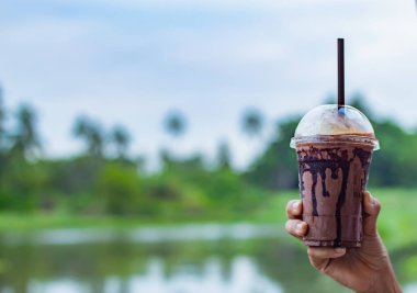 Yandan kadın ve nehir soğutma çikolata görünümü.