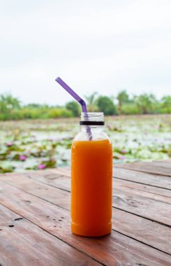 Ahşap masa üzerinde plastik şişe portakal suyu serin ve taze.