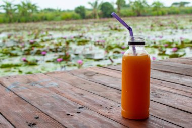 Ahşap masa üzerinde plastik şişe portakal suyu serin ve taze.