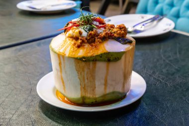 Köri karışımı balık ve sebze hindistan cevizinin içine koymak, masanın üzerine yerleştirilir.