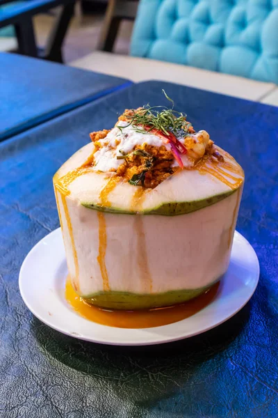 Köri karışımı balık ve sebze hindistan cevizinin içine koymak, masanın üzerine yerleştirilir.