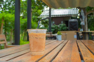 Bahçedeki ahşap bir masa üzerinde buzlu kahve.